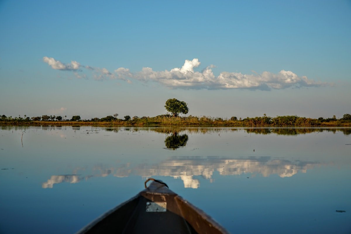 View from the bow of a small boat crossing a vast calm river in southern Africa
