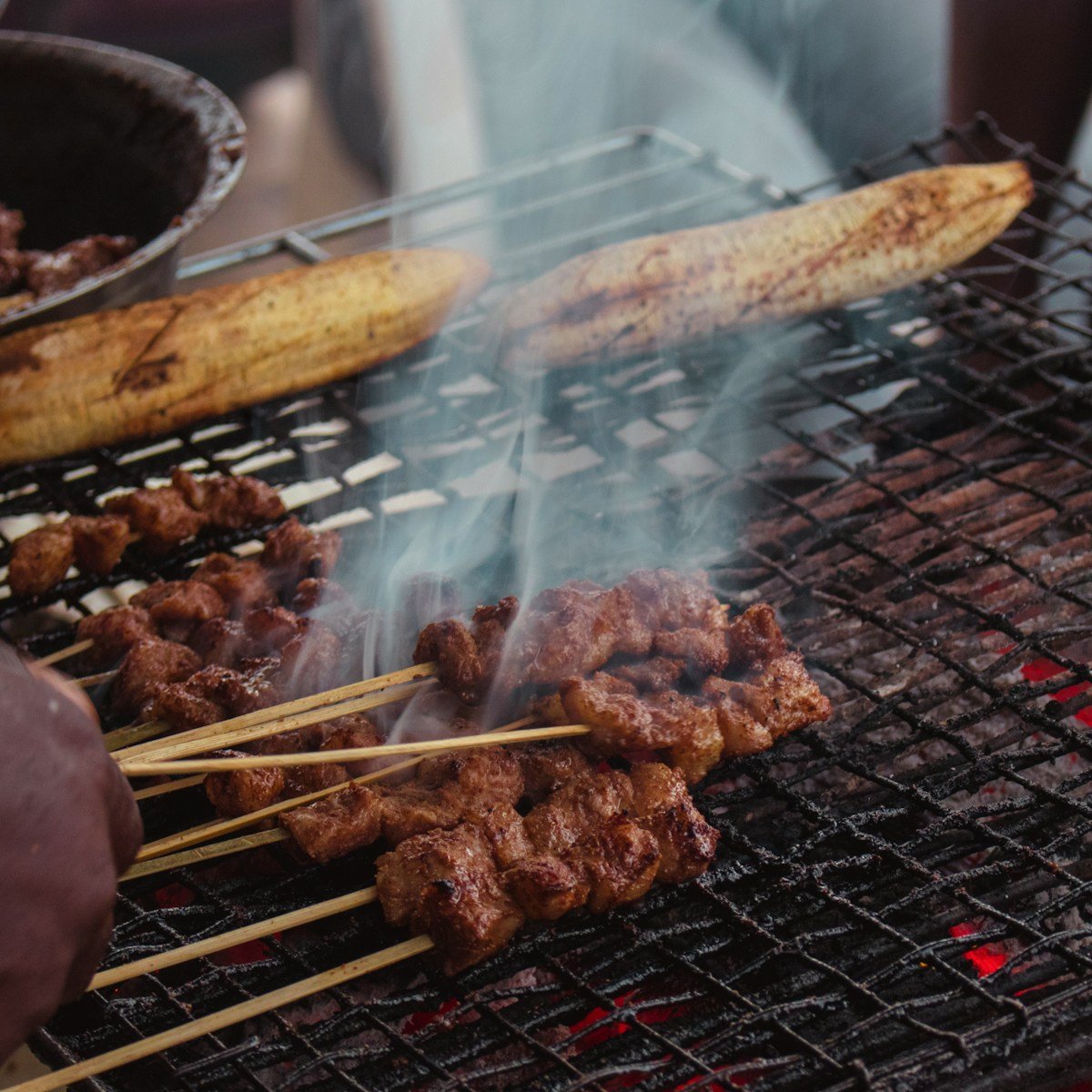 Grilled meat skewers on a charcoal grill at an African street food stall
