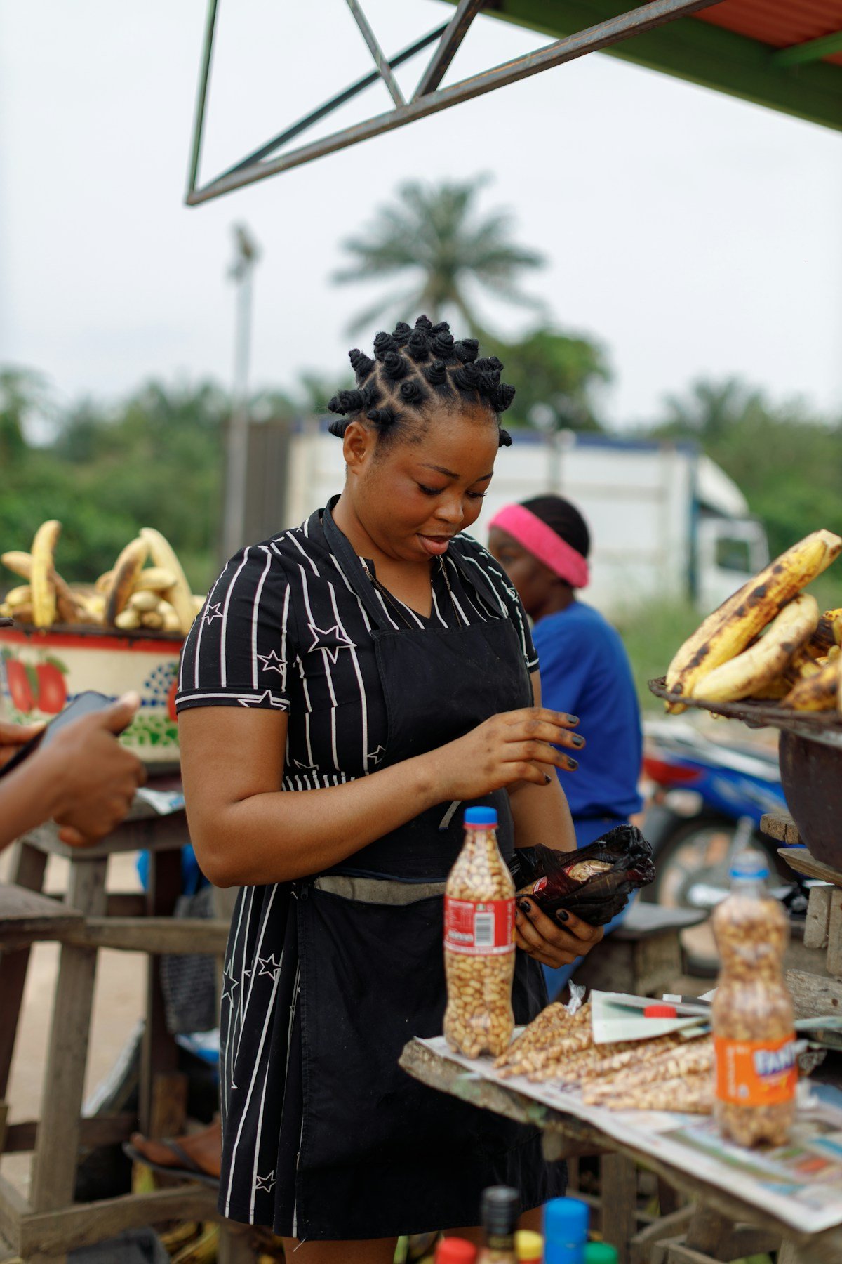 Woman preparing food at a traditional outdoor market stall in Africa