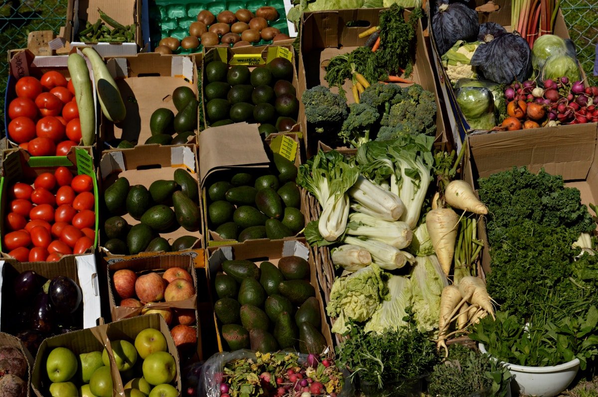 Fresh vegetables including tomatoes, avocados, leafy greens and root vegetables at a southern African market