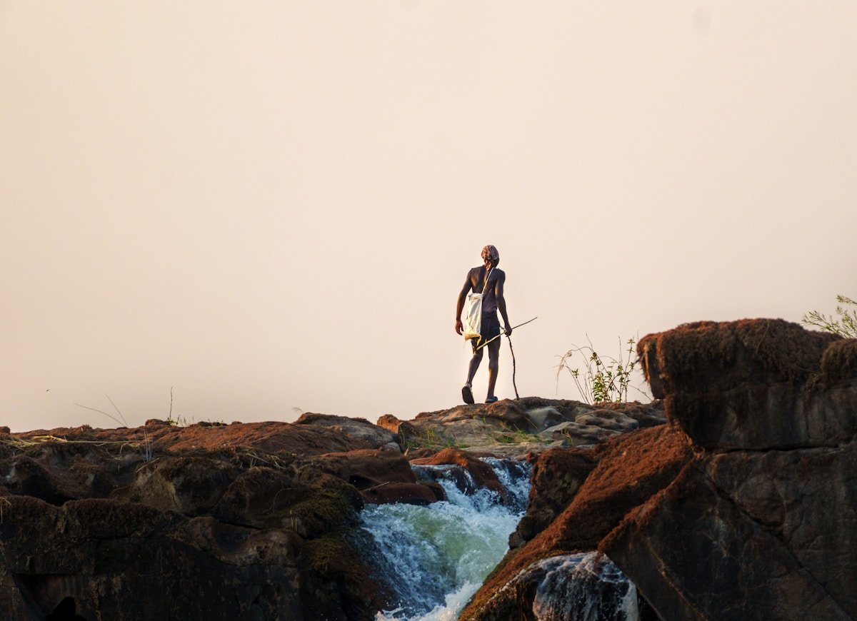 Man standing on rocks overlooking Victoria Falls, Zimbabwe