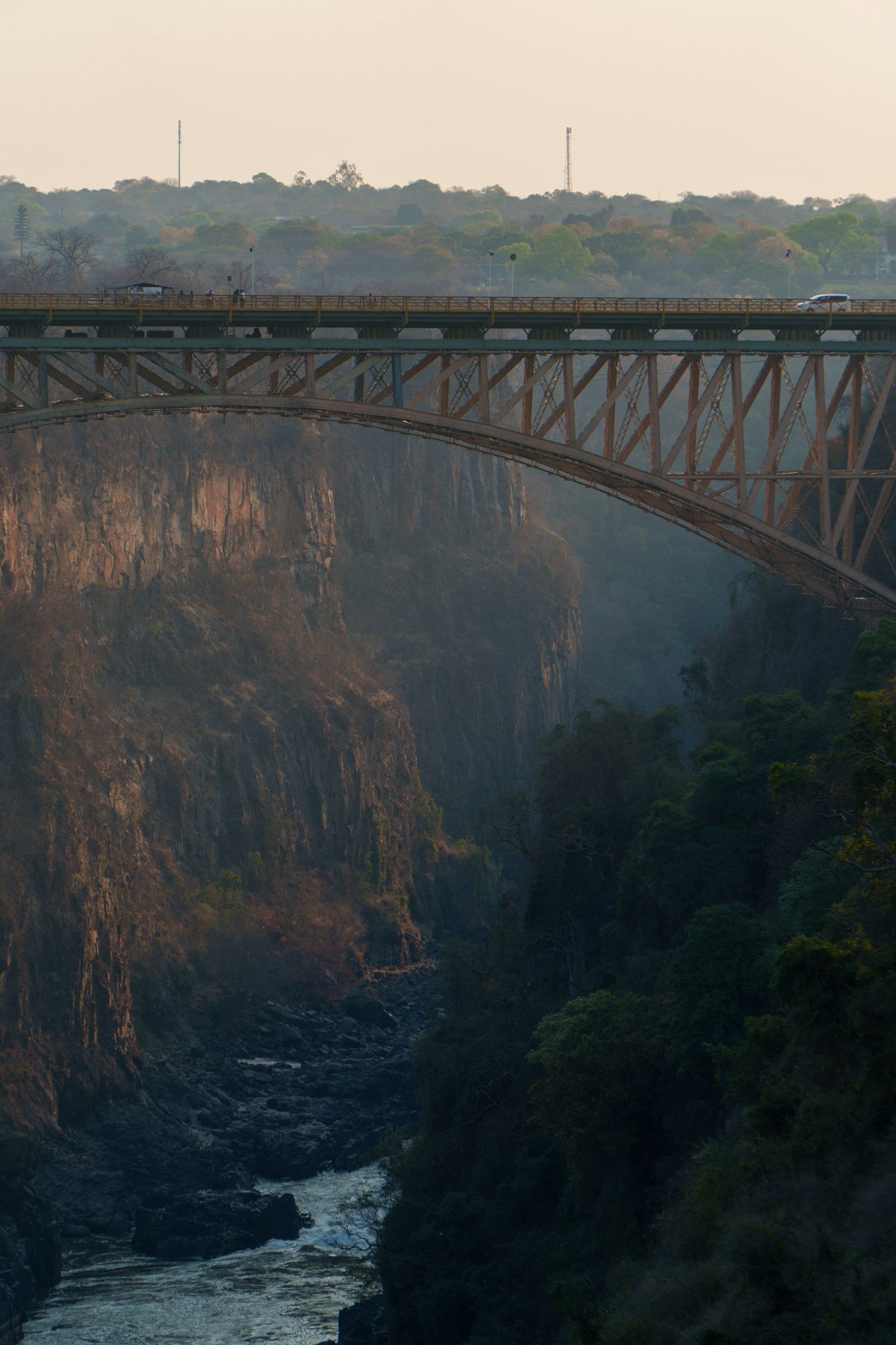 The Victoria Falls Bridge spanning the Zambezi gorge in mist, Zimbabwe