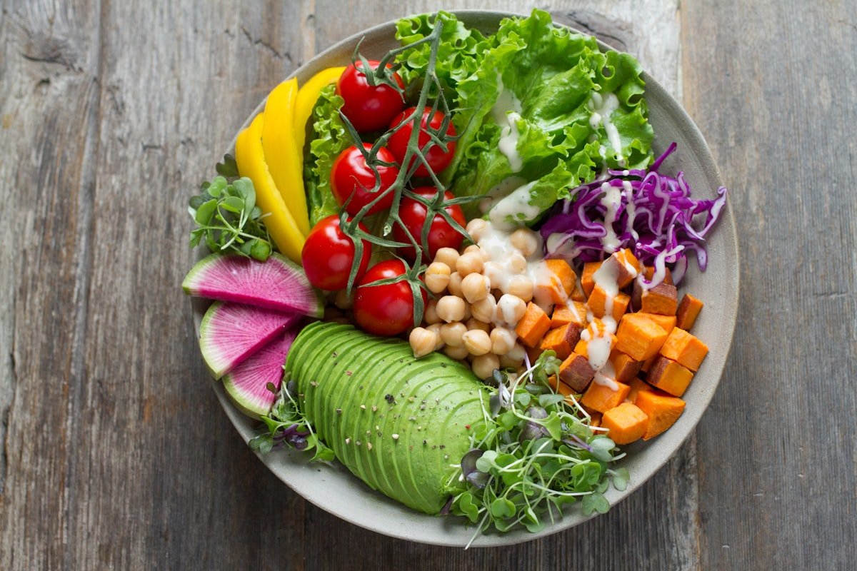 A colourful plant-based bowl with avocado, chickpeas, cherry tomatoes, and fresh greens